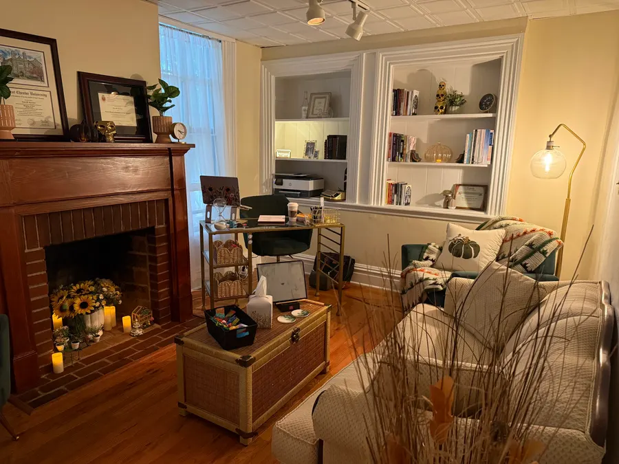 A therapy room with a fireplace, built-in shelves and sunflowers